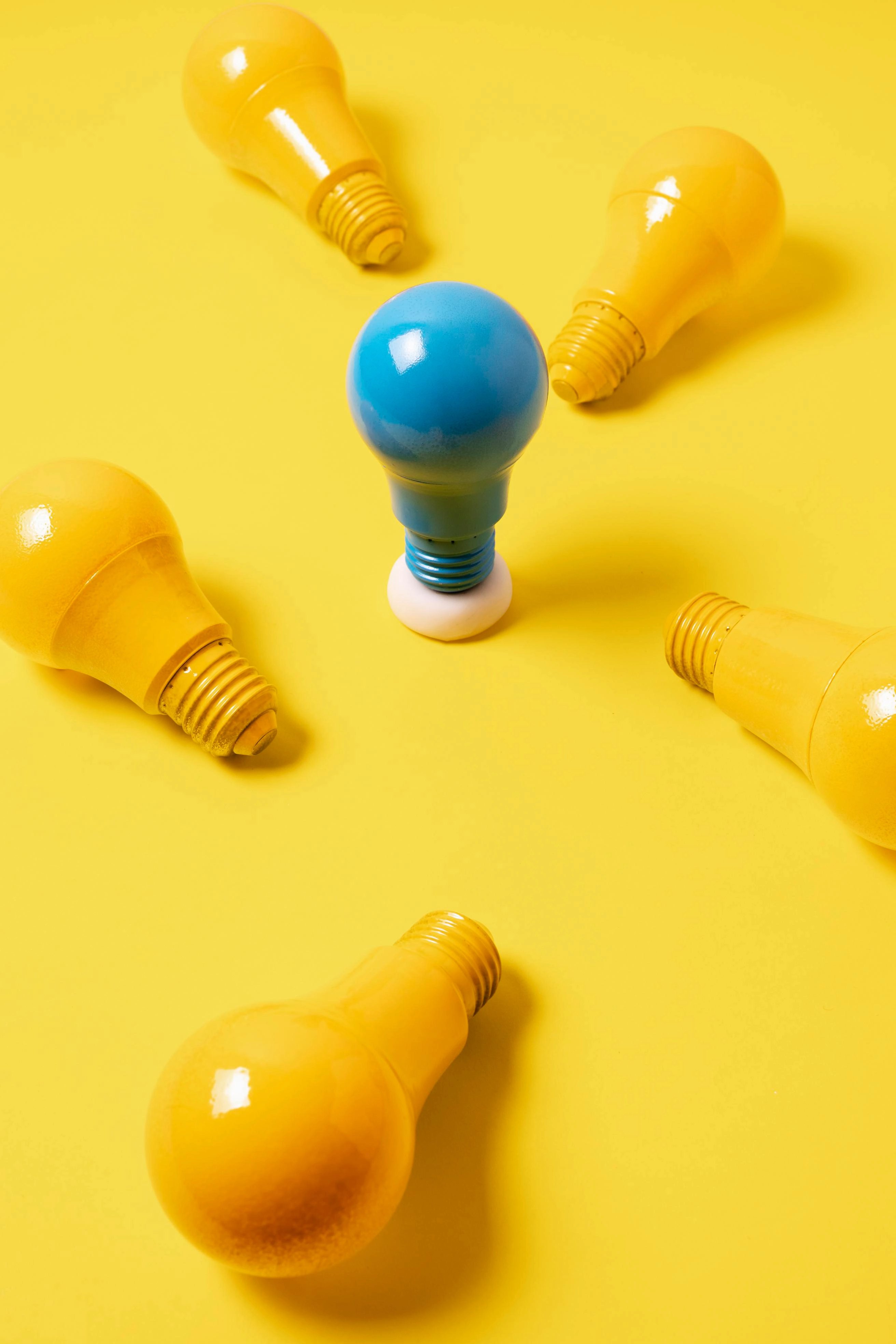 Blue light bulb standing out among yellow ones